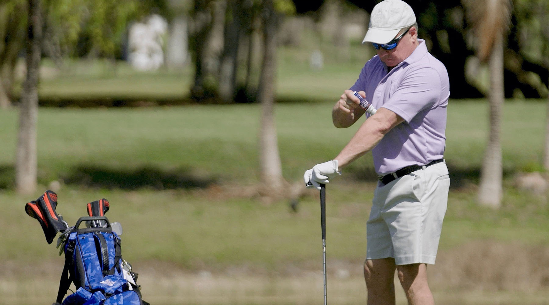 Golfer applying relieve and relax pain reliever Gel before golf